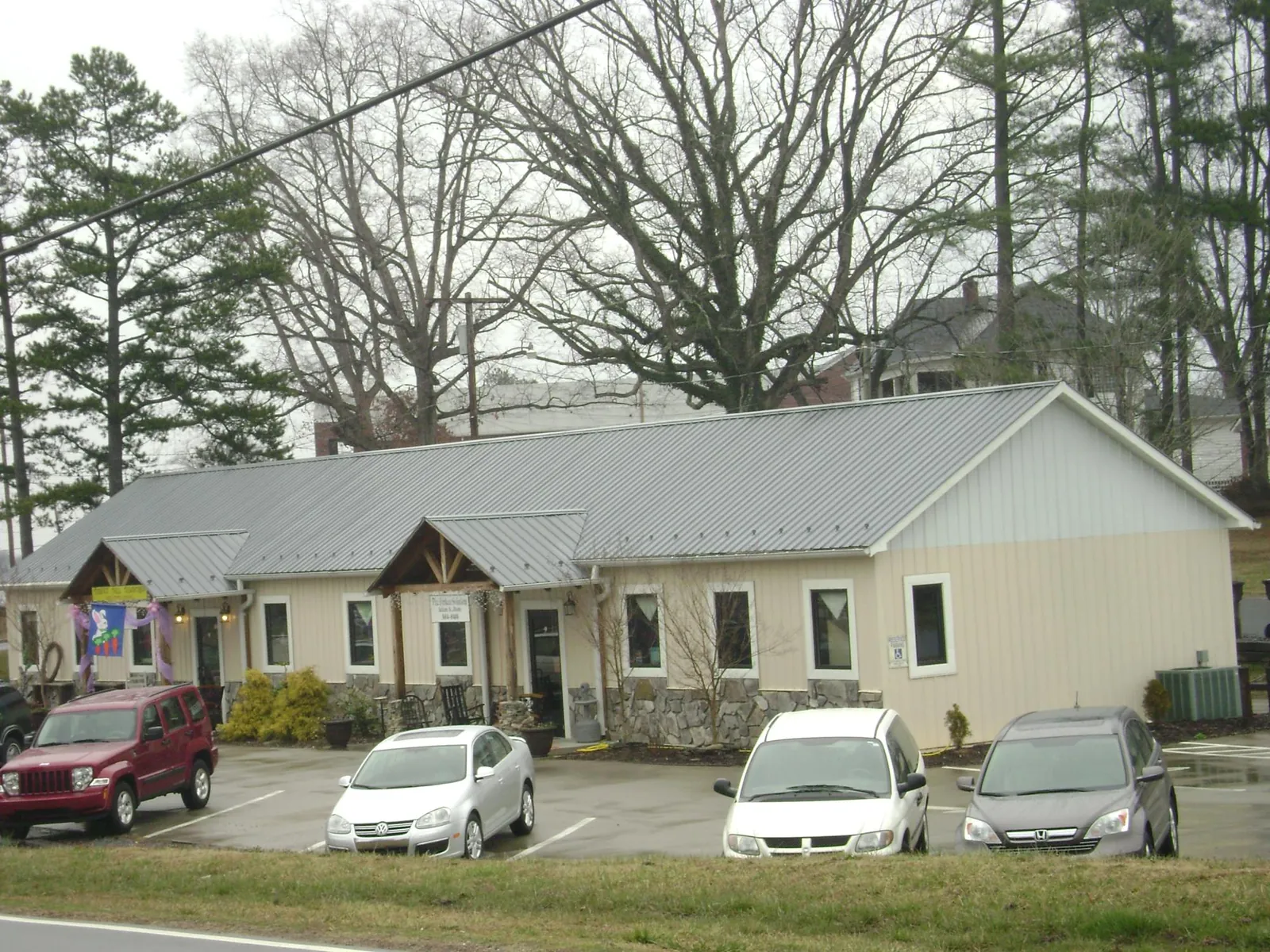 Gray metal roof with timber entry brackets on a small commercial building in Athol